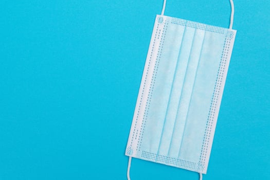 Blue Medical Mask on Blue Background Top View, Flat Lay photo