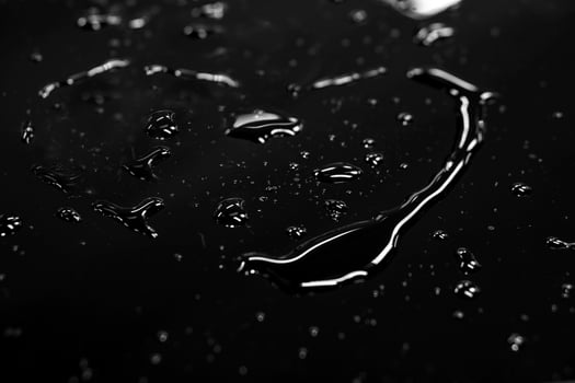Water spread in heart shape with reflection lightning on black background. photo