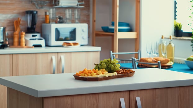 Close up of kitchen table with cheese and grapes on it. Open space room interior with daylight, design luxury arhitecture residential decoration with dining table in the middle of the room. photo