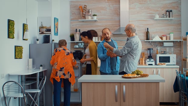 Young couple broughting the purchases from the store. Husband and wife coming from shopping bringing a paper bag with groceries, fresh food from supermarket at parents home to prepare family dinner photo