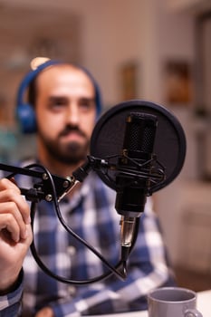Close up of vlogger holding micophone while speaking during online interview. Online show On-air production internet broadcast host streaming live content, recording digital social media communication photo
