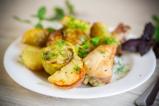 baked chicken leg with early potatoes and zucchini photo