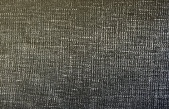 Detailed abstract texture of dark blue denim cloth. Background image of old used denim trousers fabric photo