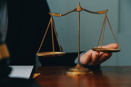 Business and lawyers discussing contract papers with brass scale on desk in office. Law, legal services, advice, justice and law concept picture with film grain effect photo