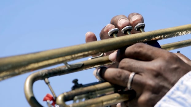 Detail of a man's hands playing a trumpet. Action. Close-up of a black man's hands playing the trumpet photo