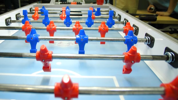 Table football soccer game kicker . Table football game, Soccer table with red and blue players. Young friends playing table football together indoors photo