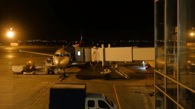 Close view of aircraft fuselage near the entering baggage door, at night. Plane takes passengers. Timelapse photo