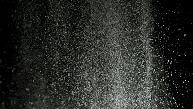White dry powder explosion with white dust falling down isolated on black background. Stock footage. Close up for white dry paints being tossed up, monochrome. photo