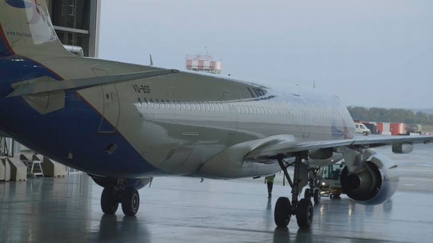 Passenger aircraft, servicing engines and repair of the fuselage, leaving the hangar of the airport. Airbus for repair in the hangar. The plane arrives from the hangar after repairs photo