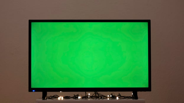 Green TV screen with flashing garland. Concept. Garland flashes on background of green TV in room. Green screen TV in empty room with festive atmosphere photo