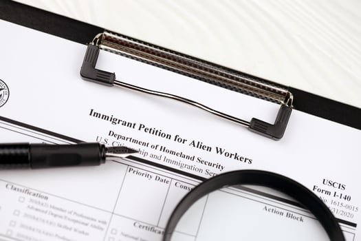 I-140 Immigrant petition for alien workers blank form on A4 tablet lies on office table with pen and magnifying glass photo