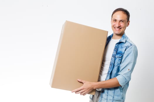 Smiling delivery man giving cardbox on white background photo