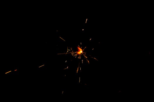 A lit sparkler showing bright sparks photo