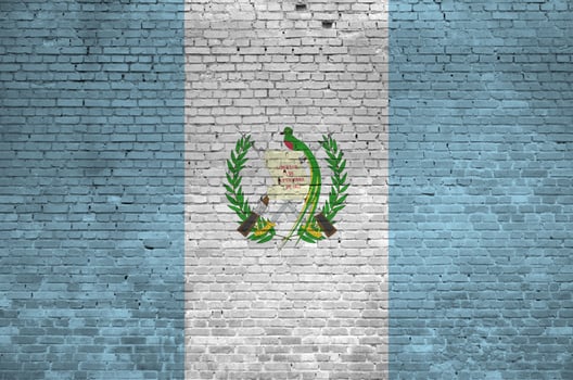 Guatemala flag depicted in paint colors on old brick wall. Textured banner on big brick wall masonry background photo