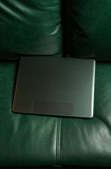 AI generated upright laptop on a green couch photo