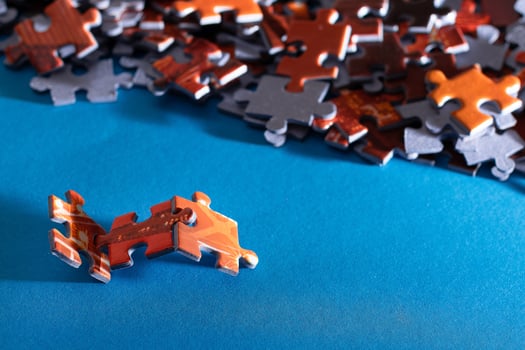 Mixed Peaces of a Colorful Jigsaw Puzzle Lie on the Blue Background Strategy and Solving Problem Concept photo