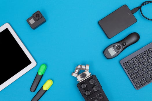 Top View of Photographer's, Videographer's or Video Blogger's Workplace. Digital Gadgets Lying on Blue Table Flat Lay photo