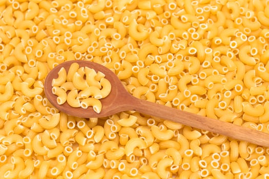 Uncooked Chifferi Rigati Pasta Background with Wooden Spoon. Fat and Unhealthy Food. Classic Dry Macaroni. Italian Culture and Cuisine. Raw Pasta photo
