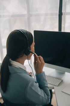Beautiful female call center operator working on computer in office photo