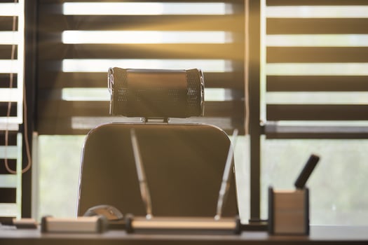 Business office workplace. Sunlight at work place for chief, boss or other employees. Table and comfortable chair. Light through the half open blinds photo
