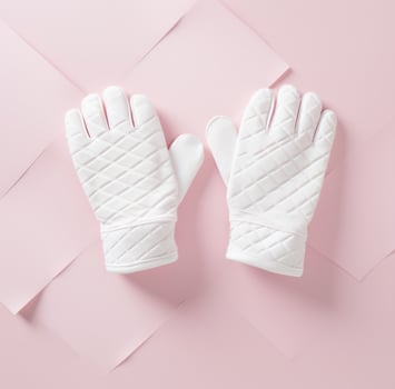 AI generated two knitted white mittens on a pink surface photo
