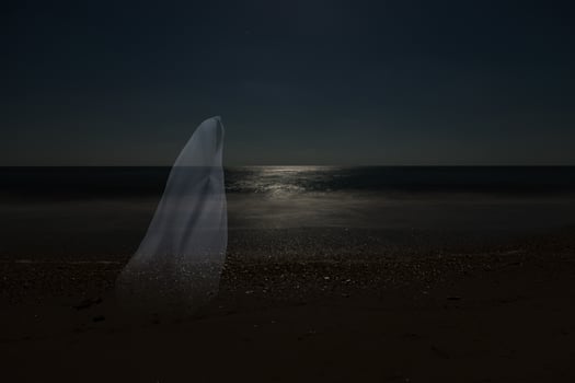 Low key image of ghost in the night on the beach. photo