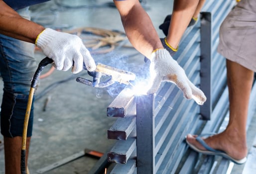 Industrial worker welding steel with sparks photo