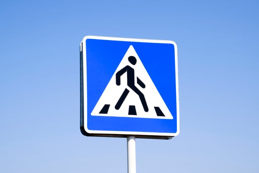 A pedestrian crossing sign. Sign on a blue sky background. photo