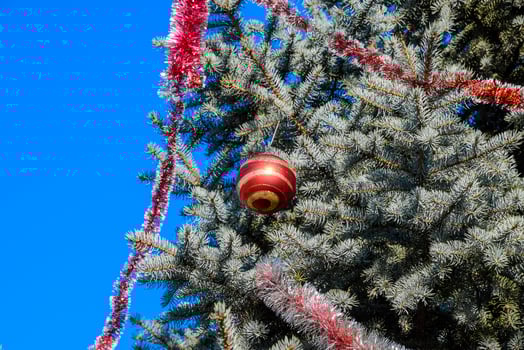 Decorations New Year tree. Tinsel and toys, balls and other decorations on the Christmas Christmas tree standing in the open air. photo