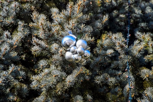 Decorations New Year tree. Tinsel and toys, balls and other decorations on the Christmas Christmas tree standing in the open air. photo