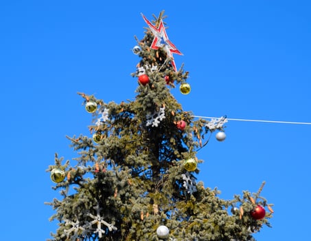 Decorations New Year tree. Tinsel and toys, balls and other decorations on the Christmas Christmas tree standing in the open air. photo