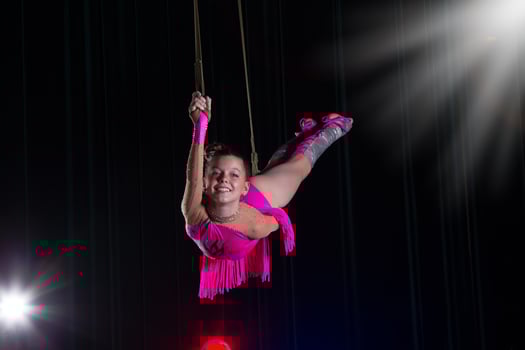Circus artist acrobat performance. The girl performs acrobatic elements in the air. Circus gymnast on the stage photo
