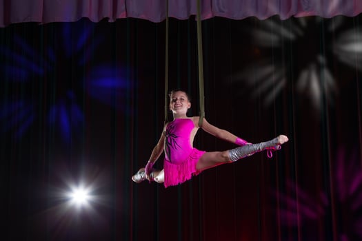 Circus artist acrobat performance. The girl performs acrobatic elements in the air. Circus gymnast on the stage photo