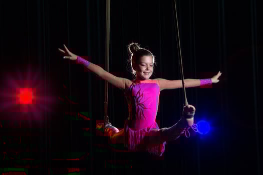 Circus artist acrobat performance. The girl performs acrobatic elements in the air. Circus gymnast on the stage photo