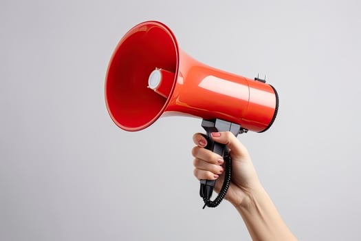 AI generated Empowered Voice Young Woman's Hand Holding a Megaphone with Copy Space on a Gray Background. photo