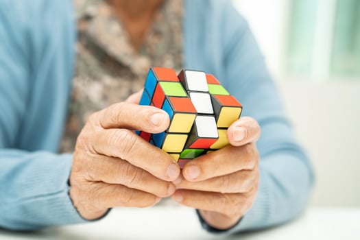 Bangkok, Thailand August 14, 2023 Alzheimer disease AD, Asian elderly woman patient playing Rubik cube game to practice brain training for dementia prevention. photo
