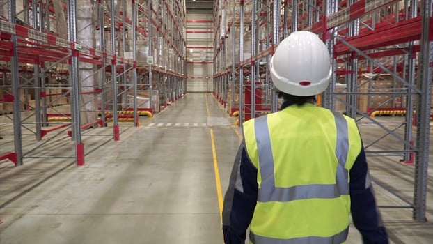 Shot of Female Industrial Worker in the Hard Hat Walking Through Heavy Industry Manufacturing Factory. Clip. Back view of female warehouse worker wearing protective goggles and helmet photo