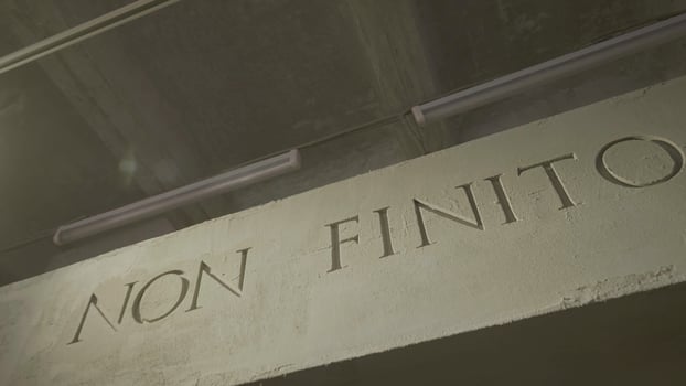 The inscription that means it is not the end on the grey wall. Isolated NON FINITO text, acronym of ancient Roman Empire. photo