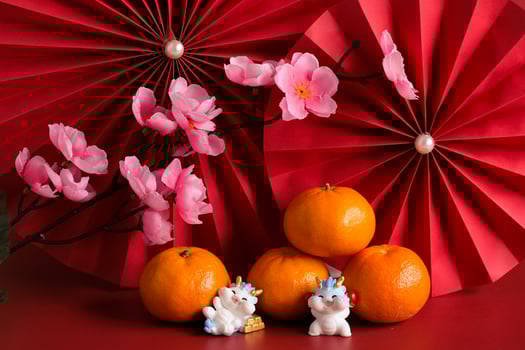 Chinese New Year of the dragon festival concept. Mandarin orange, red envelopes, dragon and gold ingot with red paper fans. Traditional holiday lunar New Year. photo