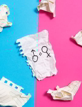 The concept of gender equality. Torn crumpled sheet of paper with painted female and male symbol on blue pink background. Equality of rights between men and women. photo