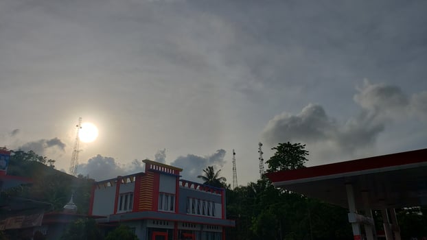 The sun is shining brightly over a gas station photo