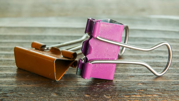 Macro from orange and purple office clips on wooden table photo