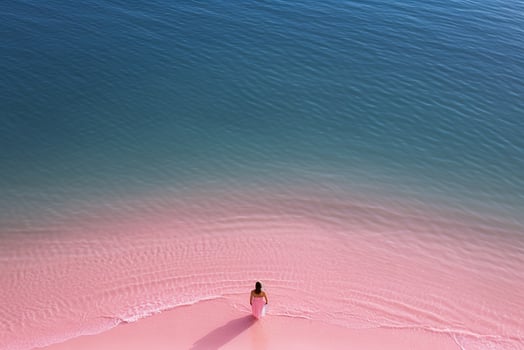 AI generated Aerial view of the woman in Pink beach and blue sea photo