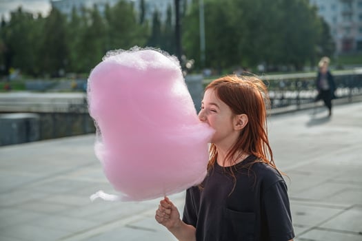 Cute girl eating big pink cotton candy photo