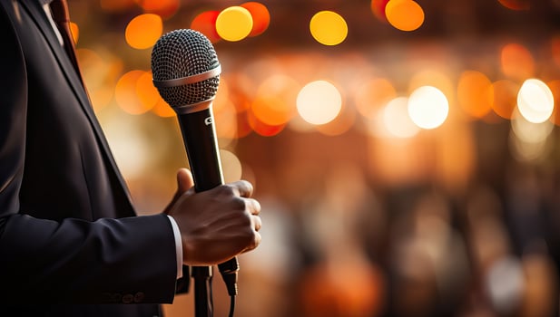 AI generated Male hand holding microphone in concert hall or conference room. Businessman speaking on stage. AI Generated. photo