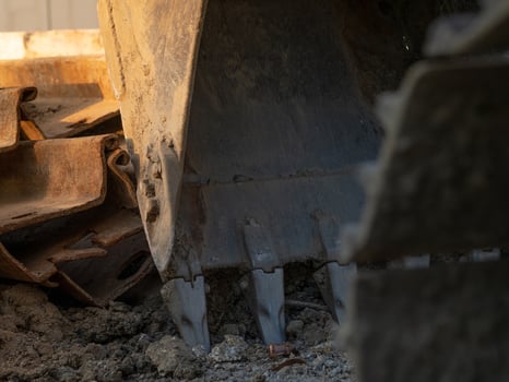 Digger parked at construction site with metal bar. Backhoe after work. Earth moving machine. Excavation vehicle. Construction site with excavator. Infrastructure development. Construction industry. photo