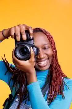 Female person taking photos with camera, having fun with images on vacation trip and sightseeing on cityscape. Young adult taking pictures of architecture and landmarks, photographs.