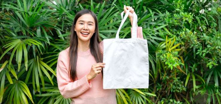 woman holding blank cotton eco tote bag. environment concept design mockup photo
