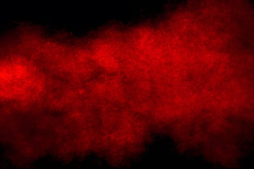 Red powder explosion cloud on black background. photo