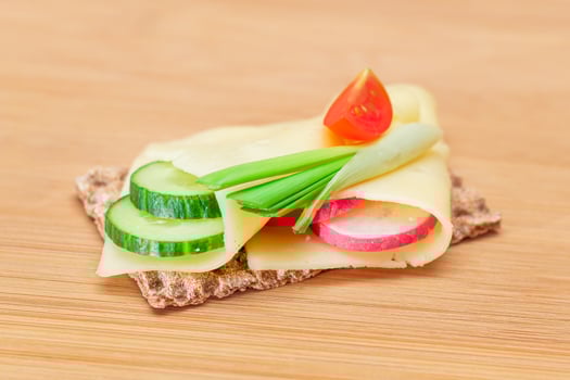 Whole Grain Crispbread with Cheese, Fresh Cucumber, Radish, Tomato and Green Onions on Cutting Board. Quick and Healthy Sandwiches. Crispbread with Tasty Filling. Healthy Dietary Snack photo